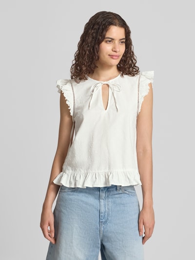 Frauenmodel trägt Regular Fit Blusentop aus reiner Baumwolle Modell 'GOLDIE' von PIECES in Weiß mit Rüschen und feiner Struktur, Ganzkörperansicht von vorne.
