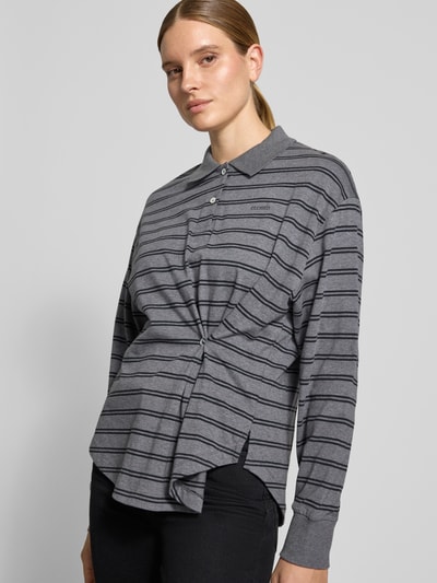 Vrouwenmodel draagt relaxed fit poloshirt uit puur katoen met plooien, logoprint, langemouwen van Closed, ruglengte maat S 68 cm, frontale busteshot.