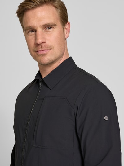 Mannelijk model draagt Regular Fit Jacke mit Umlegekragen Modell 'Motion' van SCANDINAVIAN EDITION, elastische materiaalmix, Napoleonzak, tweeweg ritssluiting, steekzakken, kleur zwart, gladde textuur, Nahaufnahme Oberkörper.