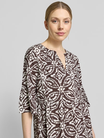 Frauenmodel trägt Regular Fit Minikleid aus reiner Viskose mit Kachel-Print von Christian Berg Woman Selection, braun-weiß, Tunika-Ausschnitt, taillierte Passform, Halbarm, Nahaufnahme Oberkörper.