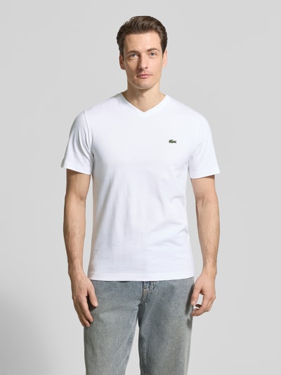 Männermodel trägt Regular Fit T-Shirt aus reiner Baumwolle von Lacoste, Optik: Unifarben, Logo-Stitching, V-Ausschnitt, Kurzarm, Ganzkörperansicht von vorne.