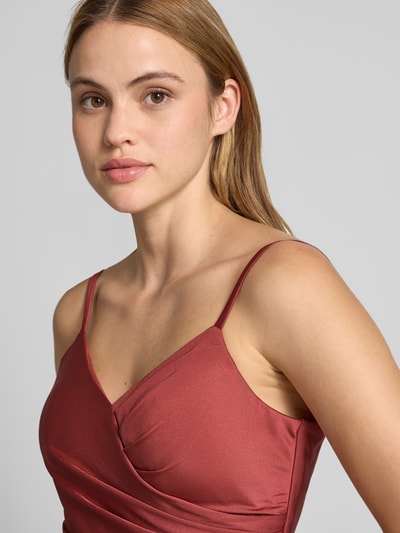 Modelka kobieca nosi Cocktailkleid mit Spaghettiträgern und V-Ausschnitt od TROYDEN COLLECTION, satyna, kolor bordowy, krój slim fit, dekolt V, ramiączka, szerokość w rozmiarze 36: 37 cm, długość pleców: 125 cm, zdjęcie zbliżeniowe górnej części ciała.