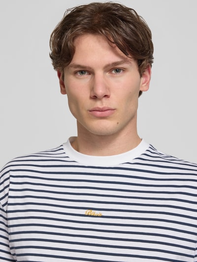 Männermodel trägt Herren T-Shirt von BLKVIS in Weiß mit dunkelblauen Streifen, Rundhalsausschnitt, Label-Stitching, Reine Baumwolle, Regular-Fit, Allover-Look, Nahaufnahme Oberkörper.