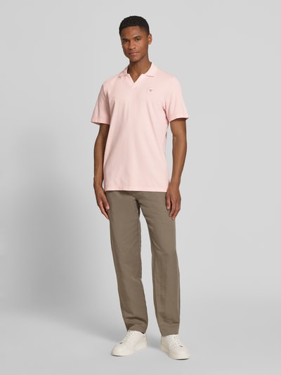 Męski model nosi Regular Fit Poloshirt aus reiner Baumwolle von s.Oliver RED LABEL, efekt: jednolity kolor, krój regular fit, naszywka z logo, kołnierzyk polo, dekolt w serek, krótki rękaw, zakończenie rękawów: prążkowane, wykończenie: z rozcięciami po bokach, wykończenie materiału: pika, materiał: bawełna, jasnoróżowy i beżowy, gładka faktura, całkowity widok z przodu