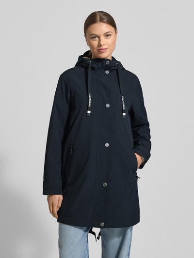 Kobiece model prezentuje Kurtka 'Jacke mit Ärmelriegeln' od NAUTGÅRD, kolor granatowy, krój regular fit, kaptur z tunelem, listwa guzikowa, kieszenie zapinane na zamek błyskawiczny, patki przy mankietach, długość tyłu w rozmiarze S: 90 cm, szerokość ramion w rozmiarze S: 45 cm, szerokość w rozmiarze S: 51 cm, długość rękawów w rozmiarze S: 62 cm, całkowity widok z przodu.