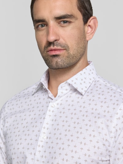 Męski model nosi Slim Fit Business-Hemd mit Kentkragen Modell 'Pio' von JOOP! z mieszanki bawełny z dodatkiem streczu, krój slim fit, jasny kolor, drobny wzór, listwa guzikowa, sportowe mankiety, kolekcja biznes, Nahaufnahme górnej części ciała.