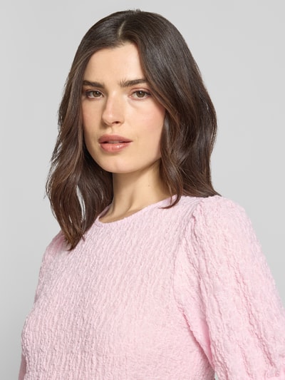 Frauenmodel trägt Blusenshirt mit Strukturmuster Modell 'FALL' von Vila in Rosa, Material-Mix mit Stretch-Anteil, Rundhalsausschnitt, Regular-Fit, Nahaufnahme Oberkörper.