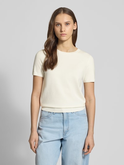 Frauenmodel trägt Strickshirt aus Viskose-Mix mit Rundhalsausschnitt von Review in Creme, Regular Fit, Rippbündchen, Ganzkörperansicht von vorne.