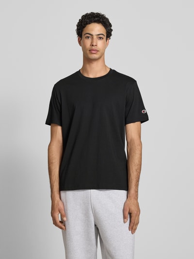 Männermodel trägt T-Shirt mit Rundhalsausschnitt im 2er-Pack von CHAMPION aus Reine Baumwolle, Regular-Fit, Label-Detail, Ganzkörperansicht von vorne.