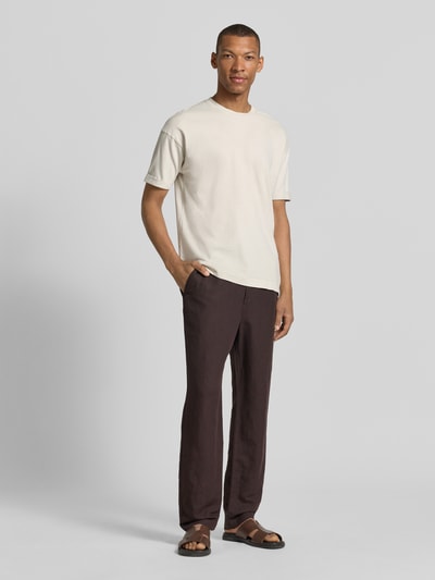 Männermodel trägt T-Shirt mit Ärmelaufschlag und Rundhalsausschnitt von Drykorn aus Reine Baumwolle, Regular-Fit, Rückenlänge 70 cm, Ganzkörperansicht von vorne.