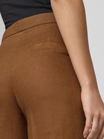 Frauenmodel trägt Straight Fit Leinenhose mit Bügelfalten Modell 'Boreli' von Mango, reine Leinen, Detailaufnahme Rückansicht.