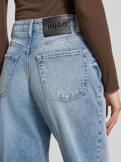 Vrouwenmodel draagt Wide Leg Jeans uit katoenmix model '937_14' van HUGO, denimlook met labelpatch, detailopname rugzijde.
