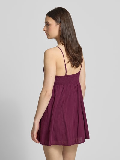 Frauenmodel trägt Minikleid aus reiner Baumwolle Modell 'PANOLA' von Only, Optik: Unifarben, Passform: Tailliert, Mini-Länge, V-Ausschnitt, Smok-Einsatz, Stickerei, Trägerform: verstellbare Spaghettiträger, Material: reine Baumwolle, Ganzkörperansicht Rückansicht.