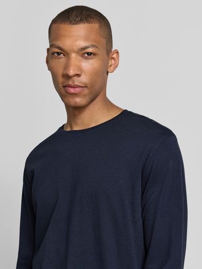Männermodel trägt Regular Fit Longsleeve aus Reiner Baumwolle Modell 'Kendrick' von Drykorn in Dunkelblau, Nahaufnahme Oberkörper, Rundhalsausschnitt, Rückenlänge bei Größe M 70 cm.