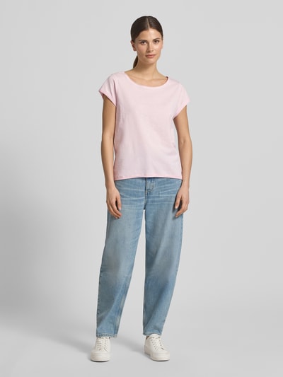 Frauenmodel trägt T-Shirt mit Rundhalsausschnitt von Christian Berg Woman aus Reine Baumwolle, Regular-Fit, Rollsaum, Ganzkörperansicht von vorne. Rückenlänge bei Größe S: 61 cm. Das Damen T-Shirt erscheint in hellem Rosa mit glatter Textur und dezentem Glanz zu einer hellblauen Jeans und weißen Sneakern.