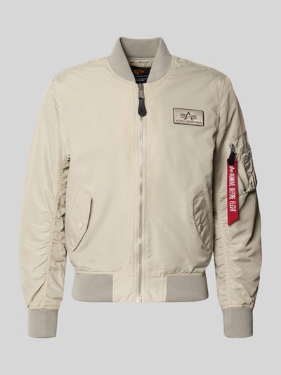 Produktfoto, Regular Fit Bomberjacke mit Logo-Patch von Alpha Industries, stójka, naszywka z logo, wpuszczane kieszenie, zamek błyskawiczny, kieszeń na rękawie z zamkiem błyskawicznym, beżowa, gładka faktura, długość tyłu w rozmiarze M: 65 cm, szerokość ramion w rozmiarze M: 45 cm, szerokość klatki piersiowej w rozmiarze M: 54 cm, długość rękawów w rozmiarze M: 69 cm