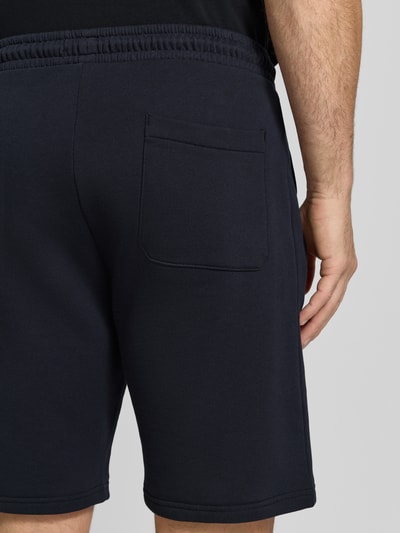 Männermodel trägt Sweatshorts mit Eingrifftaschen von Christian Berg Men in Dunkelblau, Reine Baumwolle, Regular-Fit, Detailaufnahme Rückansicht.