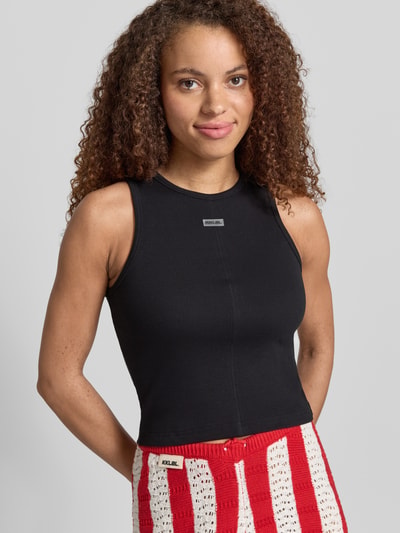 Frauenmodel trägt Tanktop mit Rundhalsausschnitt und Label-Patch von Karo Kauer, Baumwoll-Mix mit Stretch-Anteil, Feinripp, Körpernaher-Schnitt, Nahaufnahme Oberkörper