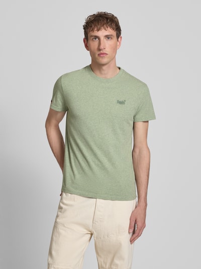 Männermodel trägt Regular Fit T-Shirt mit Logo-Stitching von Superdry aus Reine Baumwolle in Hellgrün, Rundhalsausschnitt, Ganzkörperansicht von vorne. Herren T-Shirt, Rückenlänge bei Größe M: 69 cm.