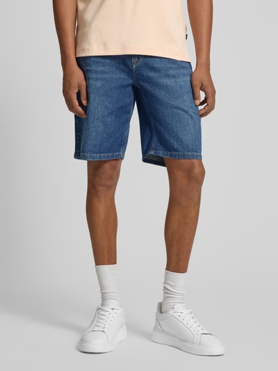 Męskimodel nosi Bermudas im 5-Pocket-Design Modell 'Fort' von JOOP! Collection, mieszanka bawełny z dodatkiem streczu, krój straight fit, zapięcie na guzik i zamek błyskawiczny, szerokość w rozmiarze 32: 48 cm, długość wewnętrzna nogawki w rozmiarze 32: 25 cm, niebieski denim, proste linie, gładka tekstura, całkowite ujęcie od przodu.