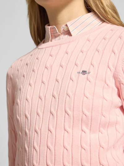 Frauenmodel trägt Strickpullover mit Zopfmuster und Label-Stitching von Gant, rosa, Baumwoll-Mix, Slim Fit, Nahaufnahme Oberkörper