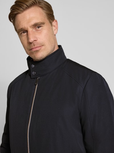Männermodel trägt Regular Fit Jacke mit Stehkragen von Christian Berg Men in Dunkelblau, glatte Textur, Nahaufnahme Oberkörper. Rückenlänge 69 cm, Schulterbreite 49 cm, Brustweite 55 cm, Ärmellänge 67 cm, Eingrifftaschen, Reißverschluss, elastische Abschlüsse.