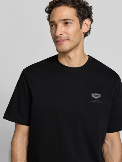 Männermodel trägt schwarzes Relaxed Fit T-Shirt aus reiner Baumwolle von Antony Morato, Logo-Detail, Nahaufnahme Oberkörper