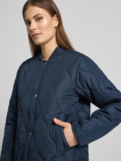 Vrouwenmodel draagt gewatteerd jack met opstaande kraag model 'FENYA 78' van Soyaconcept, regular fit, knoopsluiting, donkerblauw, ruglengte maat S 62 cm, schouderbreedte 42 cm, borstwijdte 53 cm, mouwlengte 62 cm, Nahaufnahme Oberkörper.