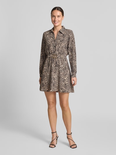 Frauenmodel trägt Hemdblusenkleid im Allover-Look mit Gürtel von Apricot, V-Ausschnitt, Knopfleiste, teils gemusterter Stoff, Ganzkörperansicht von vorne.