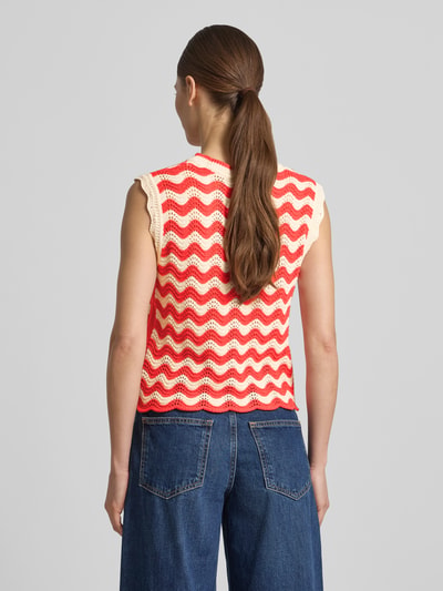 Frauenmodel trägt Pullunder im Allover-Look mit Wellensaum von Christian Berg Woman in Rot und Creme, Regular-Fit, Rückenlänge 55 cm bei Größe S, Rückenansicht Ganzkörperansicht.