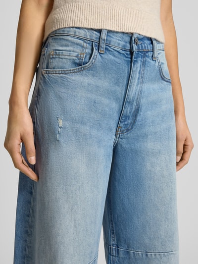 Vrouwenmodel draagt Jeans met 5-pocketmodel van Rich & Royal in katoenmix, los model, lichte blauwe kleur, knoop- en ritssluiting, detailopname bovenbeen.