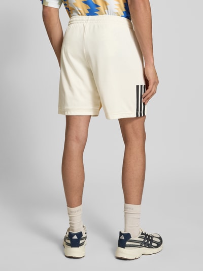 Männermodel trägt Regular Fit Sweatshorts mit Strukturmuster von adidas Sportswear in Optik: Unifarben, Strukturmuster, Ganzkörperansicht Rückansicht.