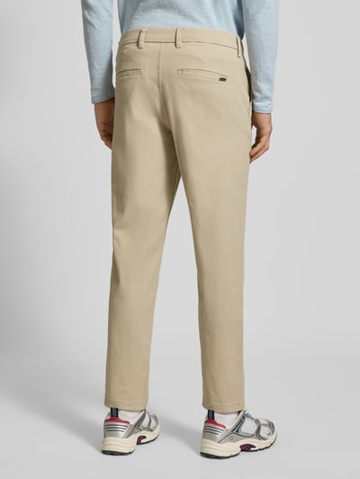 Männermodel trägt Straight Fit Chino mit Gesäßtaschen Modell 'Stollie' von JACK & JONES in beige, katoenmix, ganzkörperansicht rückansicht. Heren chino met steekzakken, knoop- en ritssluiting, bandwijdte 44 cm, binnenbeenlengte 75 cm bij maat 32/32.