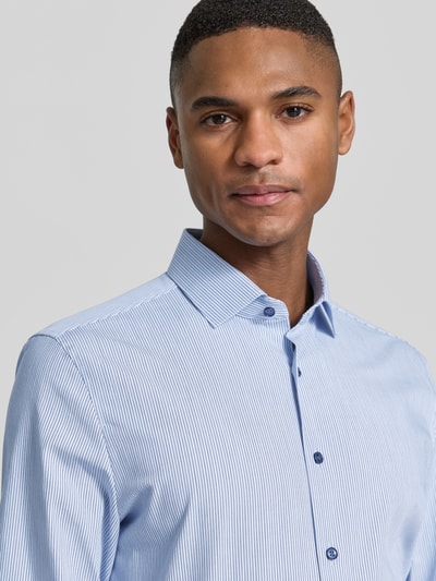 Männermodel trägt Slim Fit Business-Hemd mit Kentkragen von OLYMP Level Five, feine Streifen, Baumwoll-Mix mit Stretch-Anteil, Nahaufnahme Oberkörper.