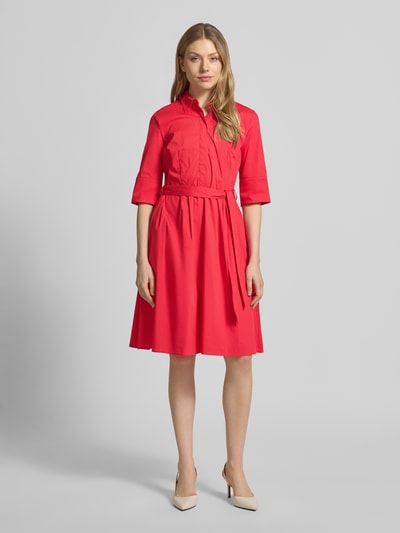 Modelka kobieca nosi knielanges Hemdblusenkleid mit Bindegürtel von Christian Berg Woman Selection, kolor różowy, bawełniany miks ze stretchem, krój A-linia, długość do kolan, zakryta listwa guzikowa, pasek, długość pleców w rozmiarze 36: 99 cm, szerokość w rozmiarze 36: 48 cm, długość rękawa w rozmiarze 36: 37 cm, widok całej sylwetki z przodu.