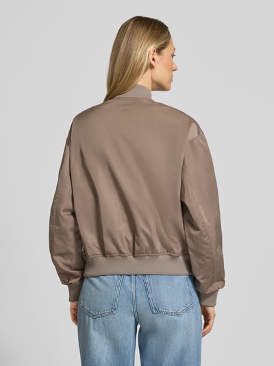 Modelka nosi Regular Fit Blouson mit College-Kragen od Marc O'Polo, efekt: jednolity kolor, satyna, krój regular fit, kołnierz college, zamek błyskawiczny, długi rękaw, zakończenia prążkowane, hydrofobowy, wpuszczane kieszenie, kieszeń na rękawie, wykończenie: splot twill, widok całej sylwetki od tyłu.