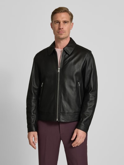 Männermodel trägt Regular Fit Lederjacke aus echtem Lammleder Modell 'MAPSON4' von BOSS, genarbtes Glattleder, unifarben schwarz, Umlegekragen, Reißverschluss, seitliche Reißverschlusstaschen, Ganzkörperansicht von vorne.