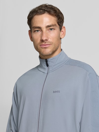 Männermodel trägt hellgraue Regular Fit Sweatjacke aus Viskose-Mix Modell 'SW_Union Tape FZ' von BOSS Green, Nahaufnahme Oberkörper.