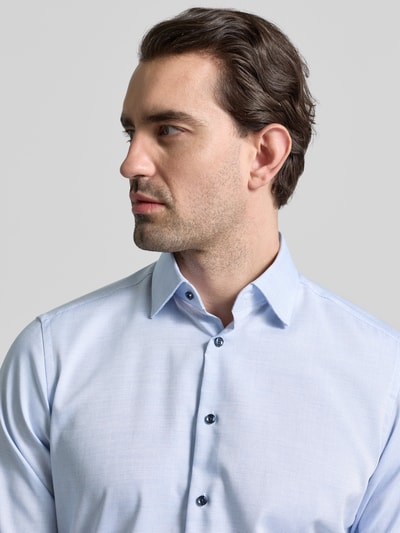 Männermodel trägt Regular Fit Business Hemd aus Baumwolle mit Kentkragen von Christian Berg Men, hellblauer Stoff, Nahaufnahme Oberkörper.