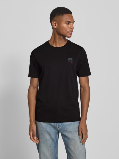 Männermodel trägt Slim Fit T-Shirt aus reiner Baumwolle Modell 'VITO2' von FIRE + ICE in Schwarz, glatte Textur, Ganzkörperansicht von vorne.