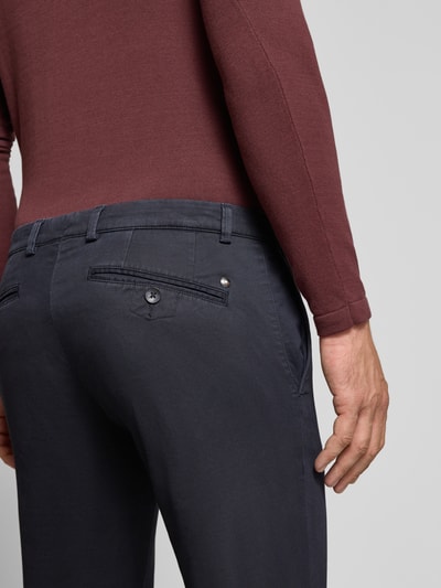 Männermodel trägt Slim Fit Chino aus Baumwoll-Mix von bugatti in Dunkelblau, Gesäßtaschen sichtbar, Nahaufnahme Rückansicht. Herren Chino aus elastischem Baumwoll-Mix, Slim Fit, mit Münztasche, Gesäßtaschen, Knopf- und Reißverschluss, Bundweite bei Größe 32/32: 41 cm, Innenbeinlänge: 81 cm.