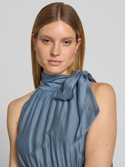 Frauenmodel trägt Cocktailkleid aus Viskose-Mix im Stufen-Look von Christian Berg Cocktail, Stehkragen, Schleifen-Applikation, Nahaufnahme Oberkörper.