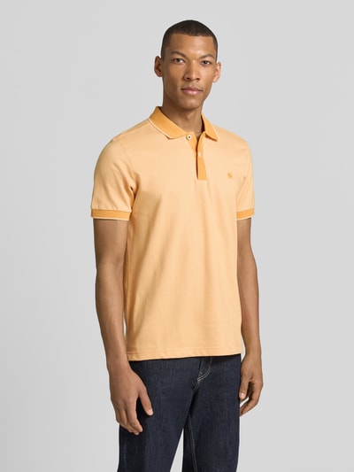 Männermodel trägt Regular Fit Poloshirt mit Logo-Stitching von Lerros in Hellorange, Polokragen, kurze Knopfleiste, Ganzkörperansicht von vorne.