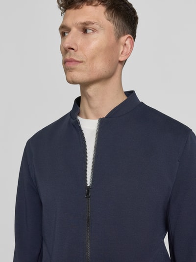 Männermodel trägt Blouson mit Zweiwege-Reißverschluss Modell 'Audio' von Zuitable, Dunkelblau, Material-Mix mit Viskose-Anteil, Regular-Fit, Stehkragen, Nahaufnahme Oberkörper.