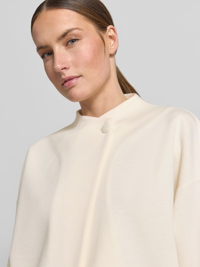 Kobiece modelka nosi Jacke Viskose-Mix mit Knopfverschluss od Rich & Royal, beżowy kolor, miękka tekstura, zbliżenie na górną część ciała.