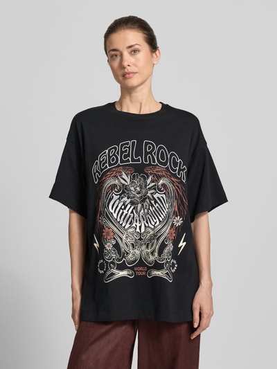 Frauenmodel trägt Oversized T-Shirt aus reiner Baumwolle Modell 'LILIE' von Vero Moda, Optik: Unifarben, Motiv-Print, Kurzarm, Ganzkörperansicht von vorne.