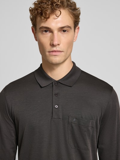 Männermodel trägt Regular Fit Poloshirt aus Baumwoll-Mix von RAGMAN, dunkle Farbe, Brusttasche, elastische Abschlüsse, Nahaufnahme Oberkörper.