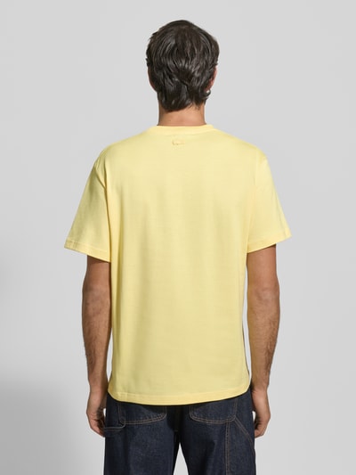 Męski model nosi Regular Fit T-Shirt aus reiner Baumwolle Modell 'JERSEY LOURD' od Lacoste, jednolity żółty, bawełna, widok całej sylwetki od tyłu.