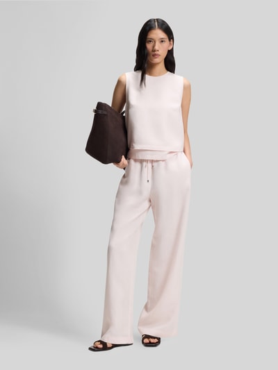 Vrouwenmodel draagt Loose Fit Leinenhose uit Lyocell-Leinen-Mix model 'TAVATI2_TI' van BOSS, look: effen kleuren, pasvorm: loose fit, labelapplicatie van metaal, sluiting: tunnelkoord, boord: elastisch, zij-steekzakken, materiaal: mix van lyocell en linnen, geheellichaamsaanzicht van voren.