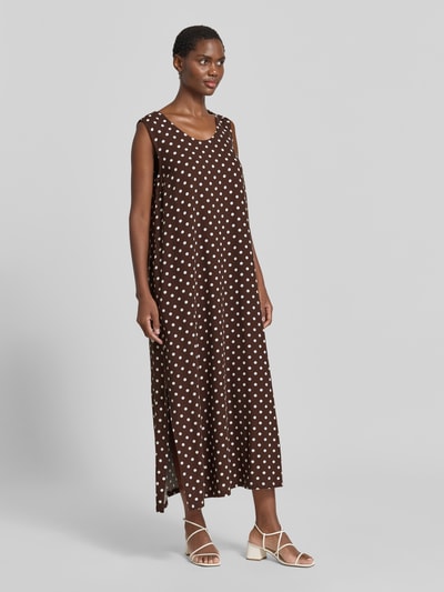 Frauenmodel trägt Midikleid aus Viskose-Mix mit Eingrifftaschen Modell 'Lavisco' von FREE/QUENT, braun mit weißen Punkten, Ganzkörperansicht von vorne. Rundhalsausschnitt, Straight Fit, Leinen-Anteil, rückseitiger Schlüsselloch-Ausschnitt.